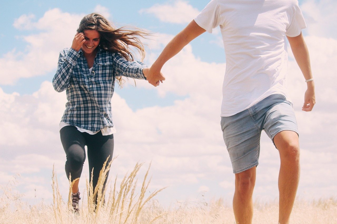 Happy couple running together outdoors, full of energy